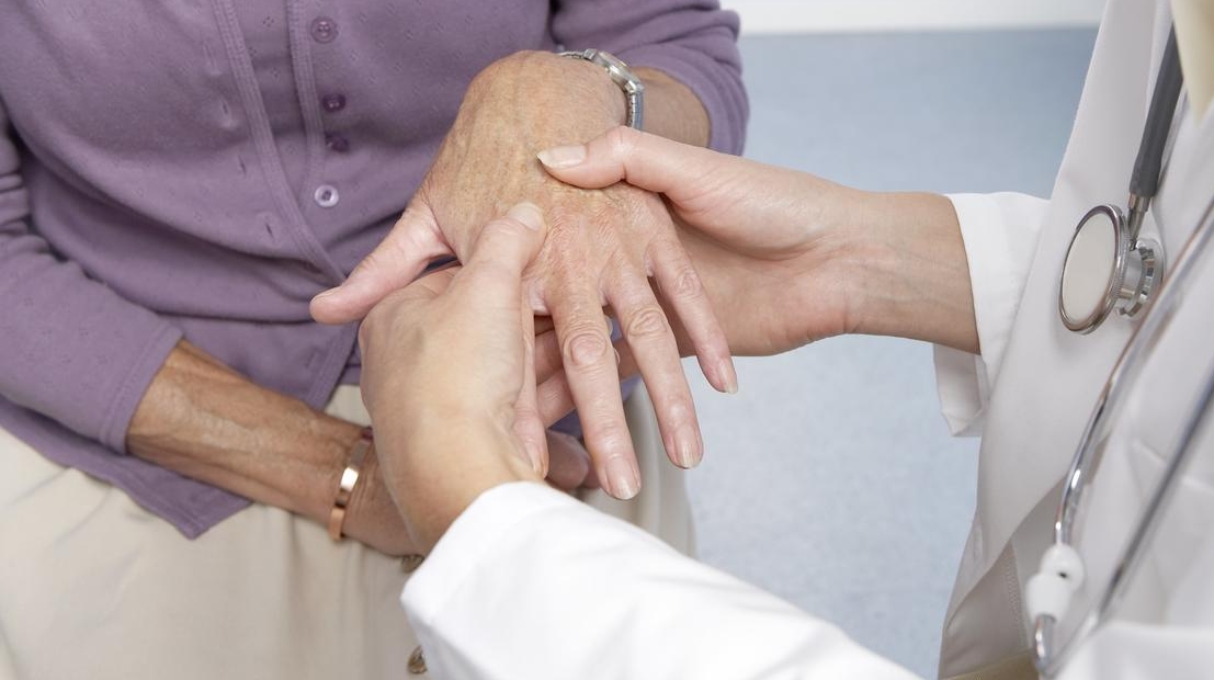Rheumatoid arthritis, general practitioner examining patient and hand for signs of rheumatoid arthri